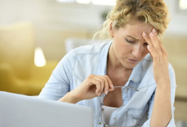 Tired woman sitting in front of laptop